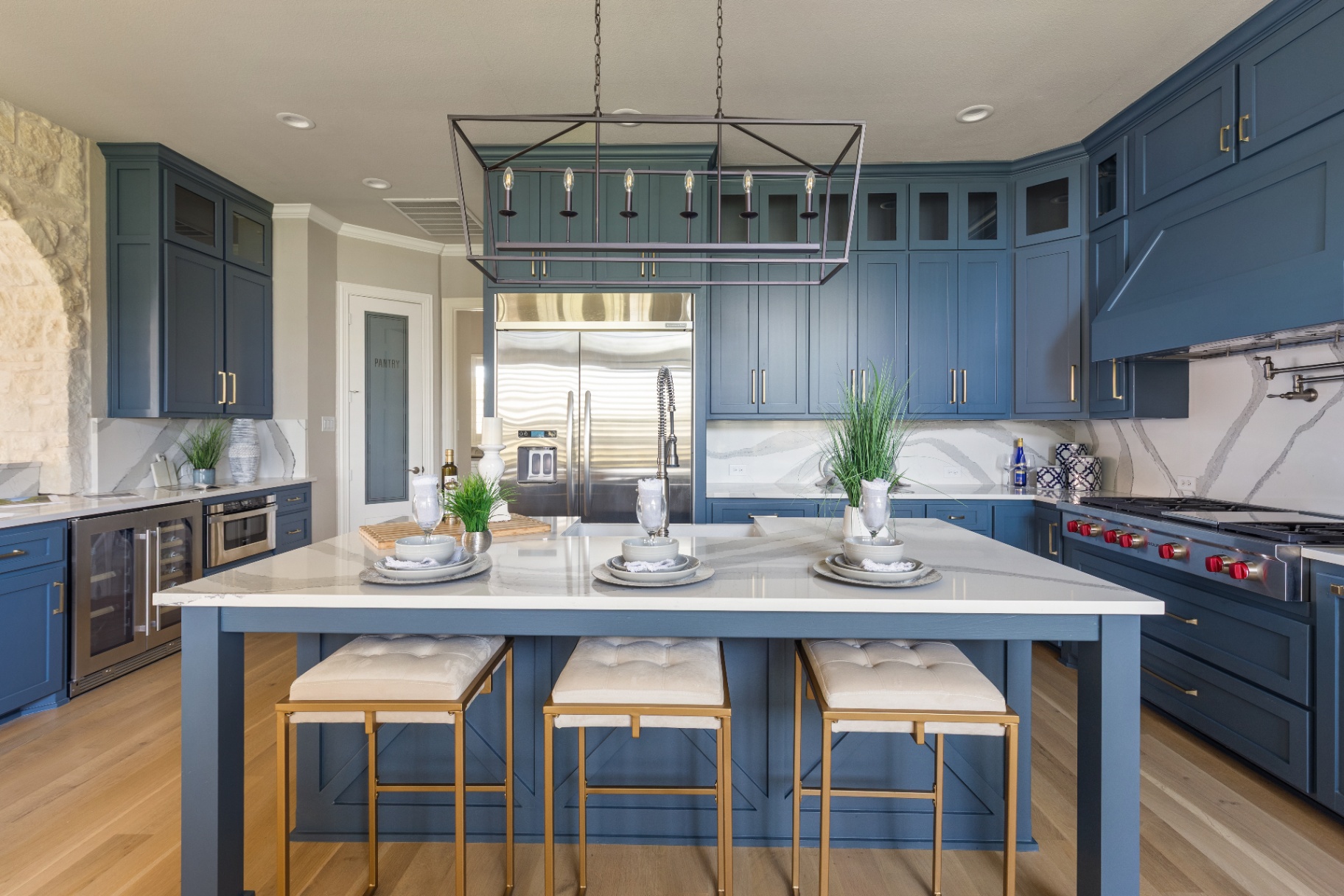 Chef kitchen with navy cabinetry and marble island